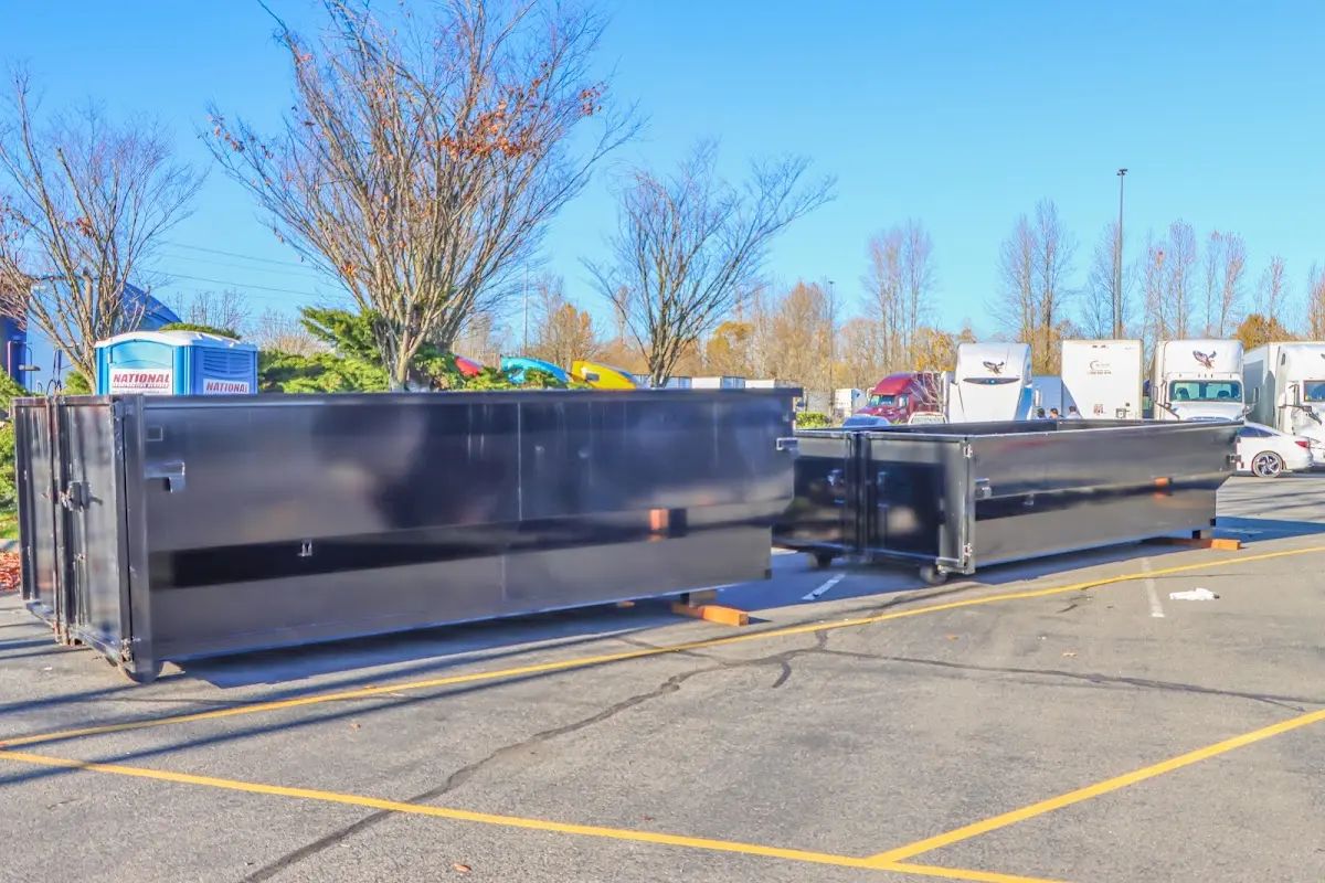 Professional dumpster rental service with roll-off container on residential driveway in Stowe